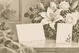 funeral etiquette for flowers: Condolence card beside cream funeral flowers