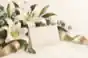 meaningful messages for funeral flowers: Funeral flower card beside white lilies