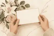 what do i say when someone dies: Hands holding a condolence card beside soft flowers